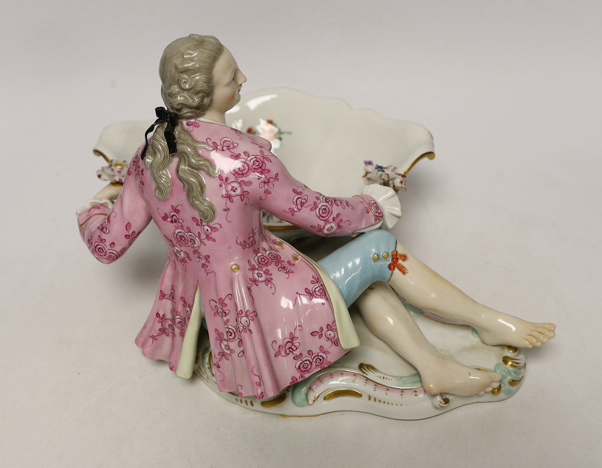 A 19th century Meissen figural sweetmeat dish with floral encrusted decoration, crossed swords mark to the base, 30cm wide